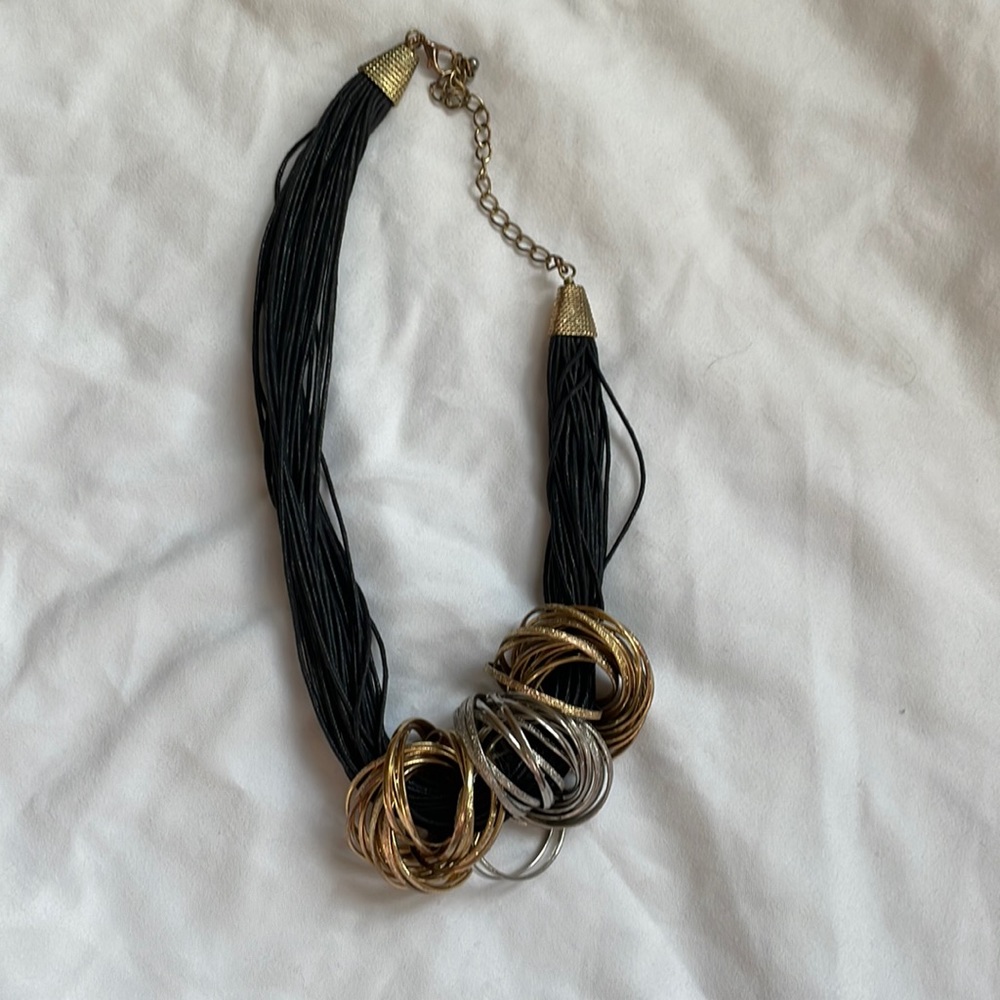 Adjustable cord necklace with gold and silver rings that are removable